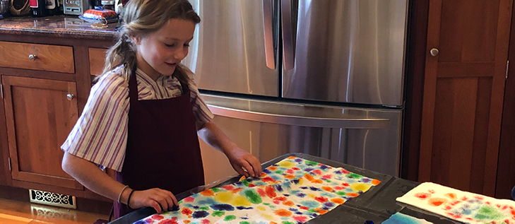 young girl in her kitchen making art