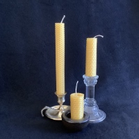 three honeycomb candles against a black background