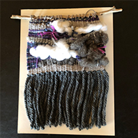 Woven wall hanging with clouds and fringe